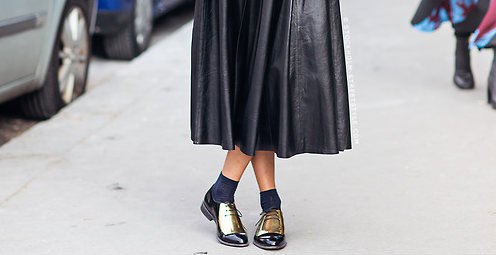 Black leather midi pleated dress with crew socks and gold wintip oxfords