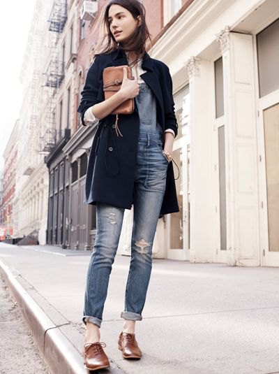 black long wool coat with gray-blue jeans with cuffs and brown shoes