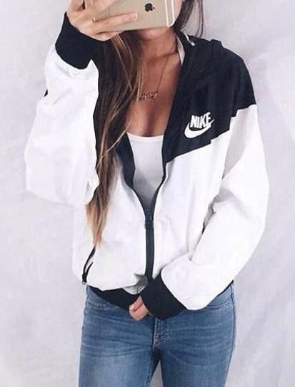 white and black Nike windbreaker with low tank top and jeans