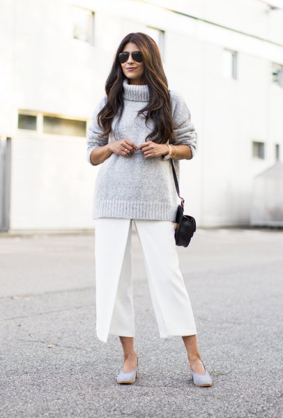 gray knitted sweater with turtleneck and white, short-cut trousers with wide legs