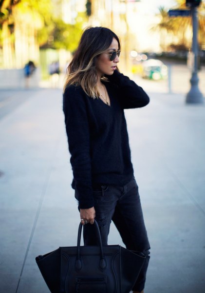 black, roughly knitted sweater with V-neck and dark, slim fit jeans