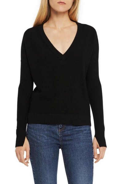 black knit sweater with low V-neck and dark blue skinny jeans