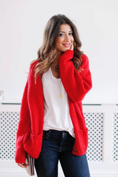 red, chunky cardigan-sweater with white t-shirt with a scoop neck and dark blue skinny jeans