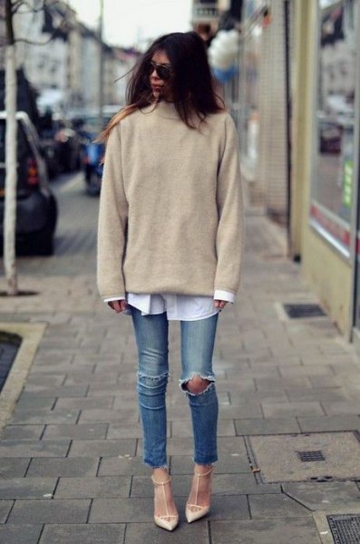 Blushing pink knitted sweater with a white shirt with buttons and torn knee jeans