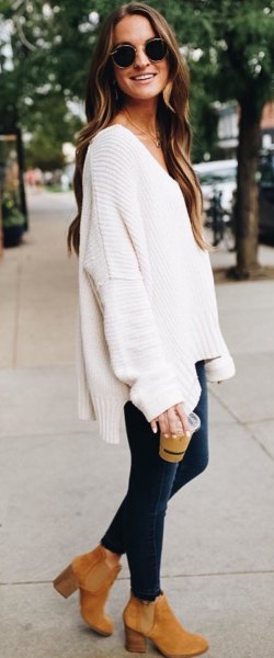 white oversized sweater with a deep v-neck and black skinny jeans