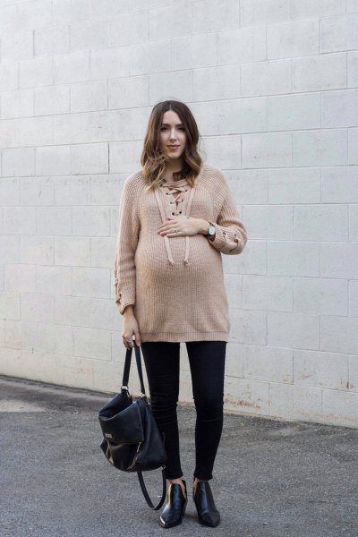 Light brown oversized sweater with black jeans with cuffs and leather boots