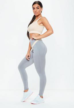 Light pink crop top with gray, high waisted, seamless leggings and white sneakers