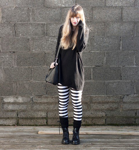black tunic sweatshirt with striped leggings and boots in the middle of the calf