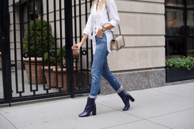 white blouse with buttons, jeans with cuffs and dark blue ankle boots with heels