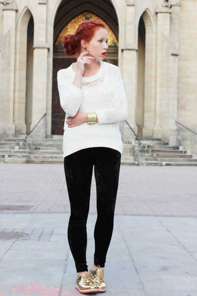 white knit sweater with black skinny jeans and gold low-top sneakers