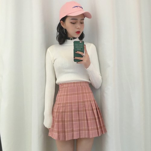 white mock neck sweater with pink, high waisted, pleated mini skirt