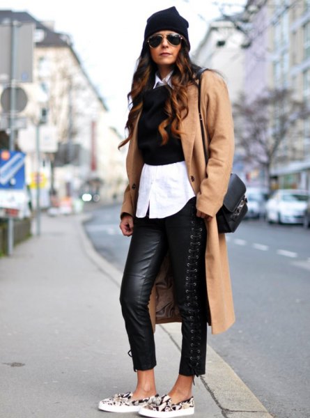Camel longline wool coat with black leather leggings and canvas shoes with animal motif