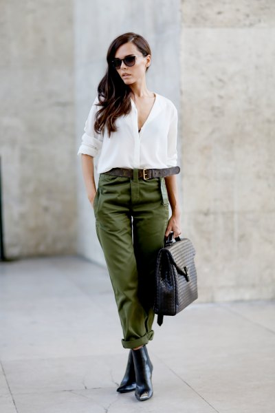 white chiffon blouse with button closure, trousers with green belt and leather chelsea boots