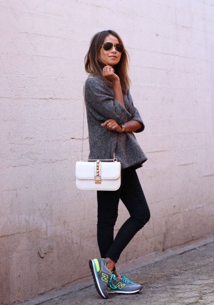 gray fleece sweater with white handbag and black skinny jeans