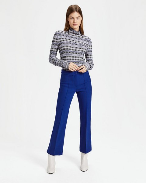 black printed sweater with mock neck and blue flared trousers