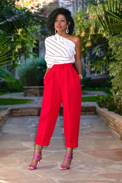 white and gray striped top with one shoulder and red trousers with wide legs