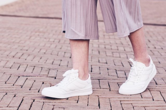 gray striped chiffon trousers with wide legs and white sneakers