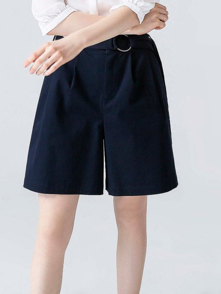 white shirt with buttons and black, flowing designer shorts