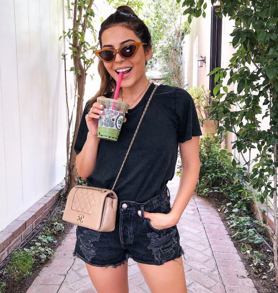 black t-shirt with torn denim shorts and pink purse
