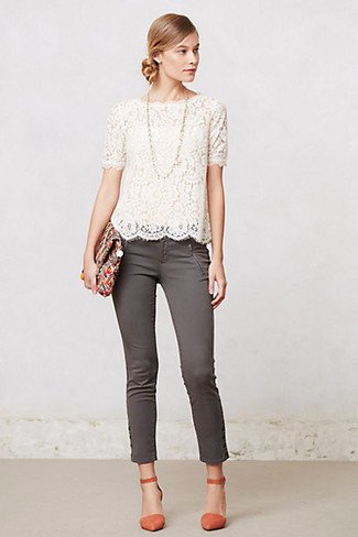 white short-sleeved lace blouse with scalloped hem and gray skinny jeans with ankles