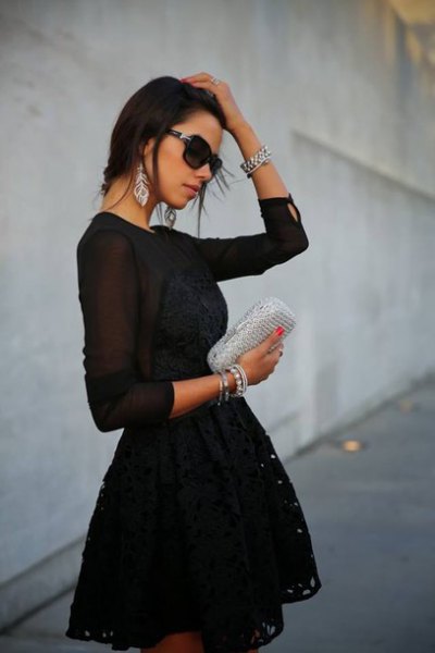 black long sleeve mini dress made of chiffon with fit and flap with silver clutch handbag