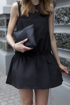 black tank top with mini rat skirt and leather handbag