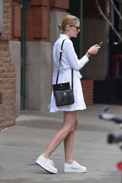 white, long-sleeved shirt dress with fit and flap and black handbag over the shoulder