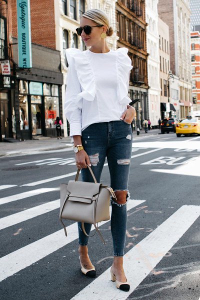 white ruffle shoulder blouse with torn gray skinny jeans