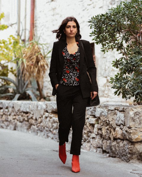 black blazer with printed top with a scoop neckline and brown boots on the boot