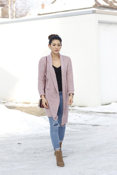 pink cardigan with black V-neck and torn jeans