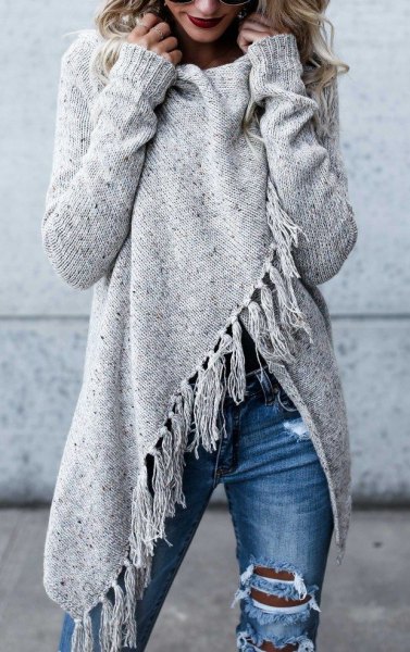 gray wrap sweater with fringes and blue, destroyed jeans