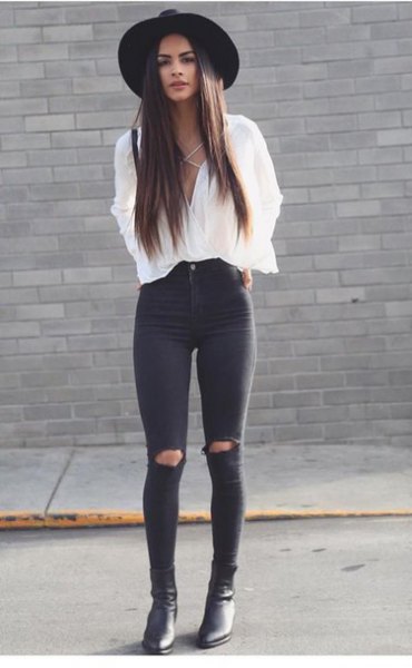 white blouse with v-neck and black skinny jeans with knee tear