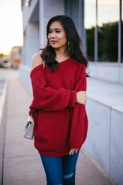 red, chunky tunic sweater with blue jeans