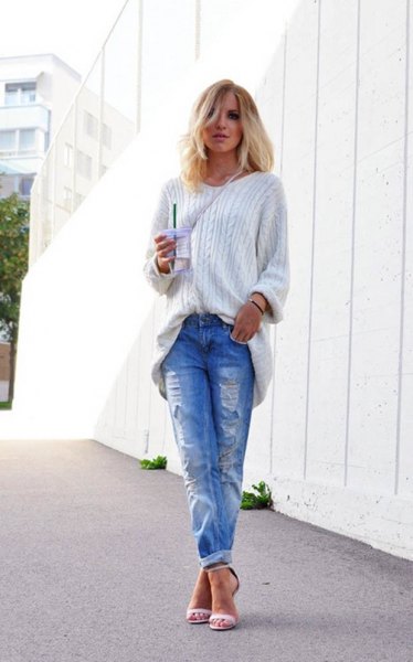 white, coarse-grain knit sweater with blue torn jeans with cuffs