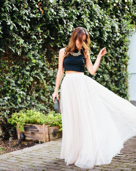 black, short, sleeveless top with white, high waisted maxi pleated skirt