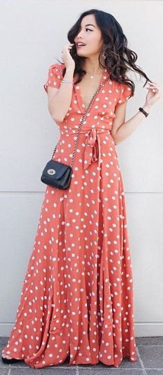 floor-length flared dress in orange and white with polka dots