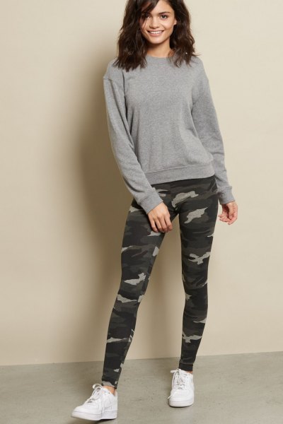 gray, chunky sweater with camouflage leggings and white sneakers