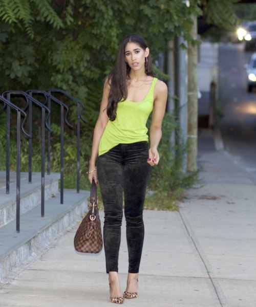 yellow tank top with a deep scoop neck and black, narrow velvet pants