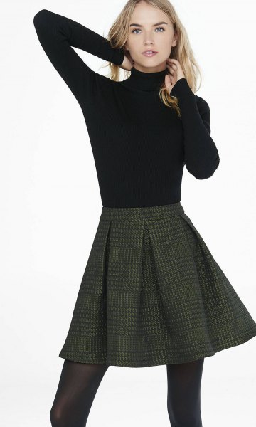 black sweater with stand-up collar and dark red checked mini skirt