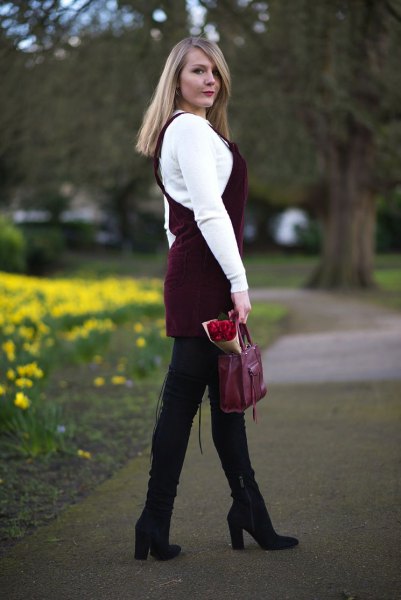 white sweater with black cord dress and black high-heeled boots