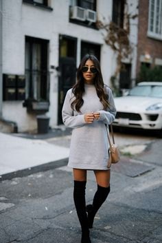 gray sweatshirt dress with a round neckline and black, thigh-high boots