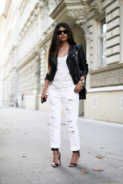 black leather moto jacket with white tank top and straight leg jeans and cuff