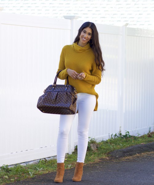 Mustard yellow, ribbed sweater with a waterfall neckline and white skinny jeans