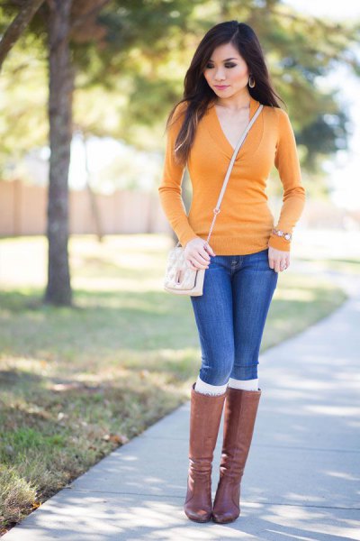 V-neck sweater, blue jeans and gray knee-high boots