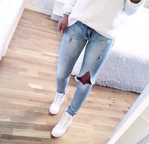 white casual fit knit sweater with light blue ripped jeans and boots