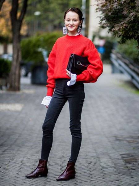 red sweater with black high waist slim jeans and ankle boots