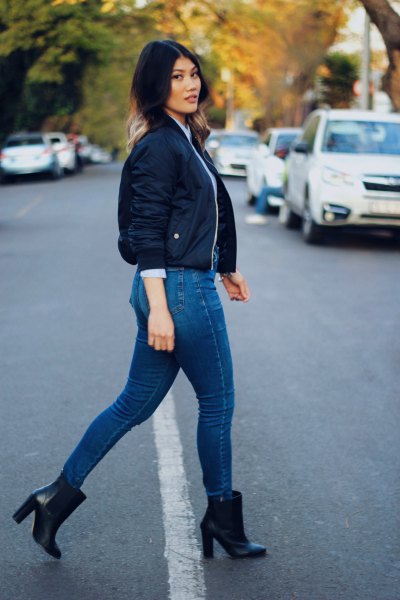 dark blue fitted short bomber jacket with jeans and heeled boots