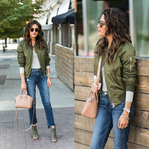 green flying jacket with gray long-sleeved tee and cropped jeans