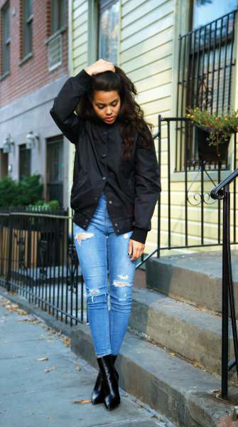 black jacket with blue high-ripped ripped skinny jeans and leather boots