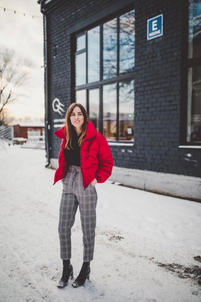 red padded jacket with black sweater with hair loss and plaid cropped pants